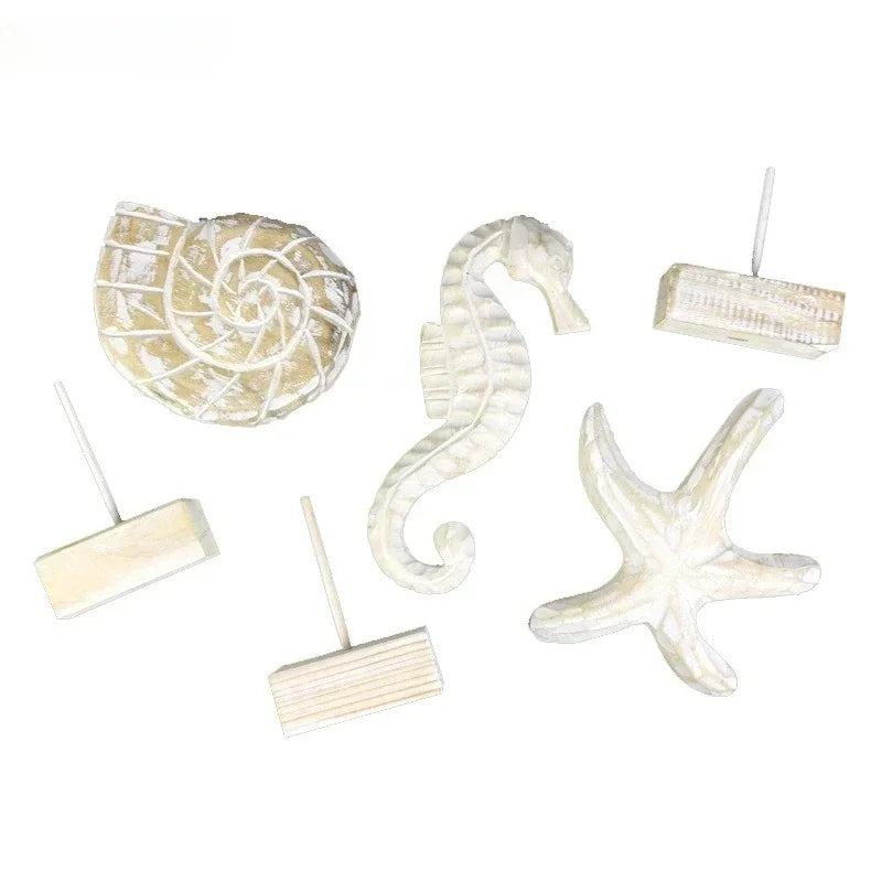 Set of decorative items shaped like a shell, seahorse, and starfish on a white background