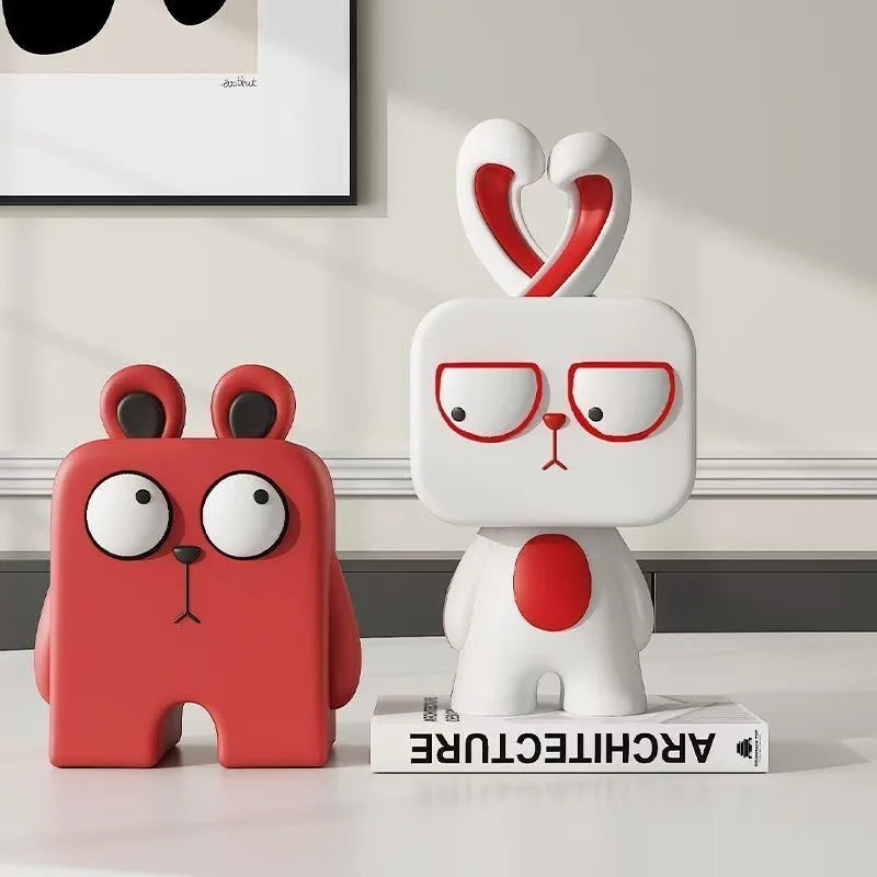 Two cartoon-style lamps, one red and one white with a heart on its head, on a surface.
