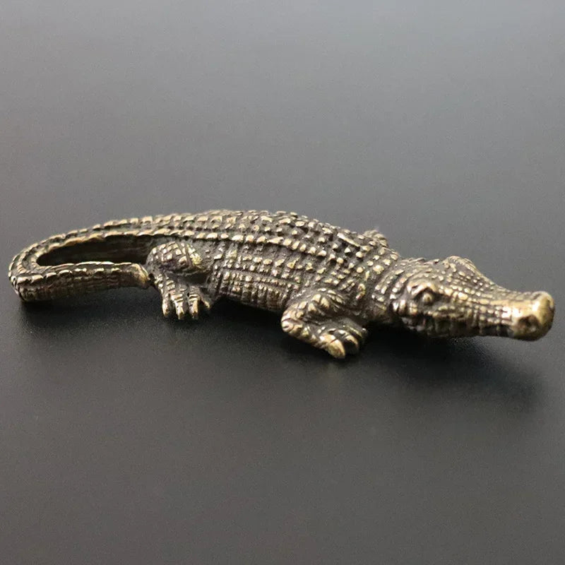 Bronze alligator figurine on a dark gray background
