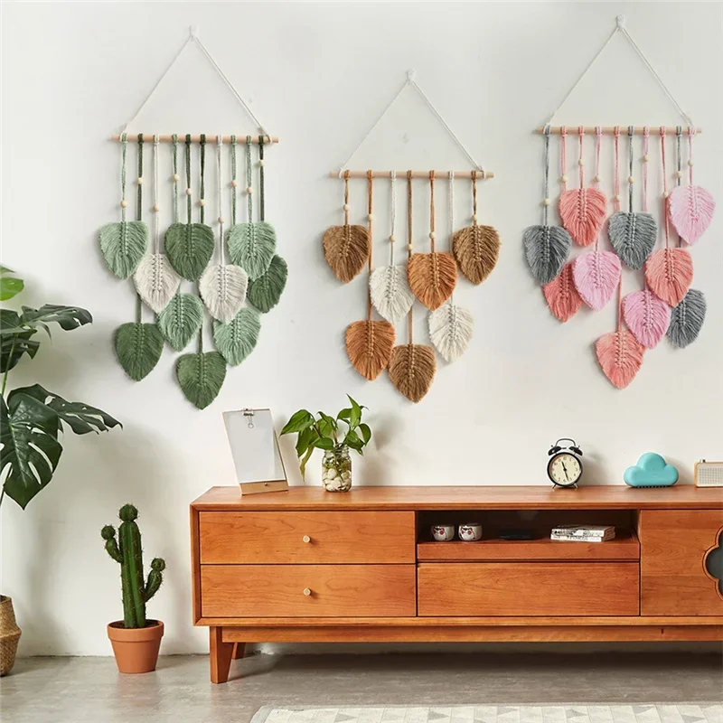 Decorative wall hangings with leaf patterns above a wooden cabinet.