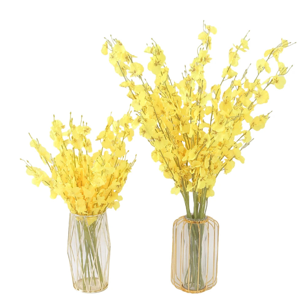 Two clear glass vases filled with yellow artificial flowers on a white background