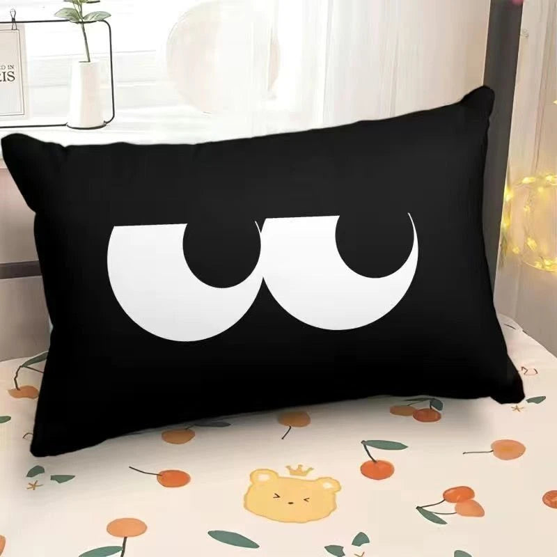 Black pillow with white crescent moon design on a bed with a floral pattern