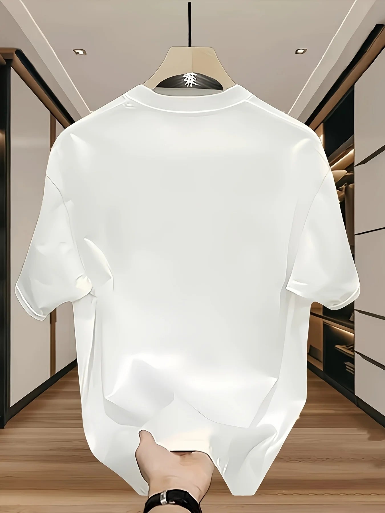 White t-shirt on a hanger with a blurred indoor background