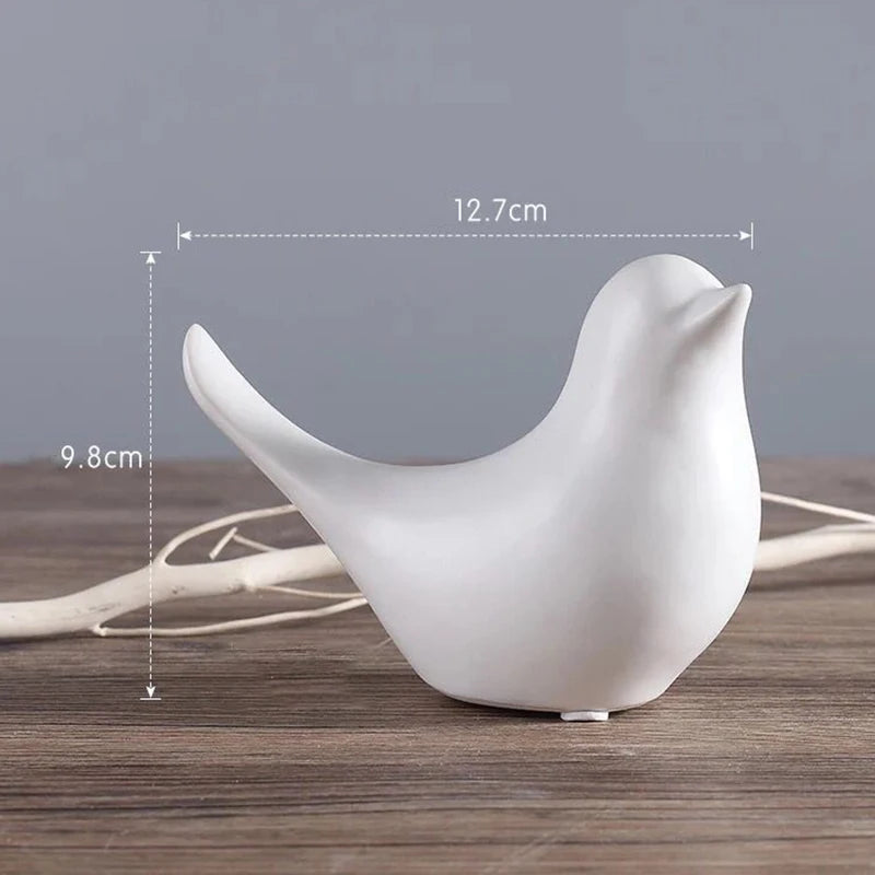 White ceramic bird figurine with measurements on a wooden surface and gray background