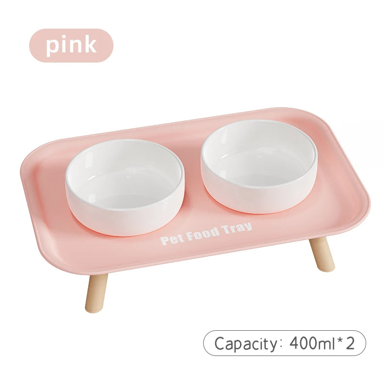 Pink pet food tray with two white bowls on a white background