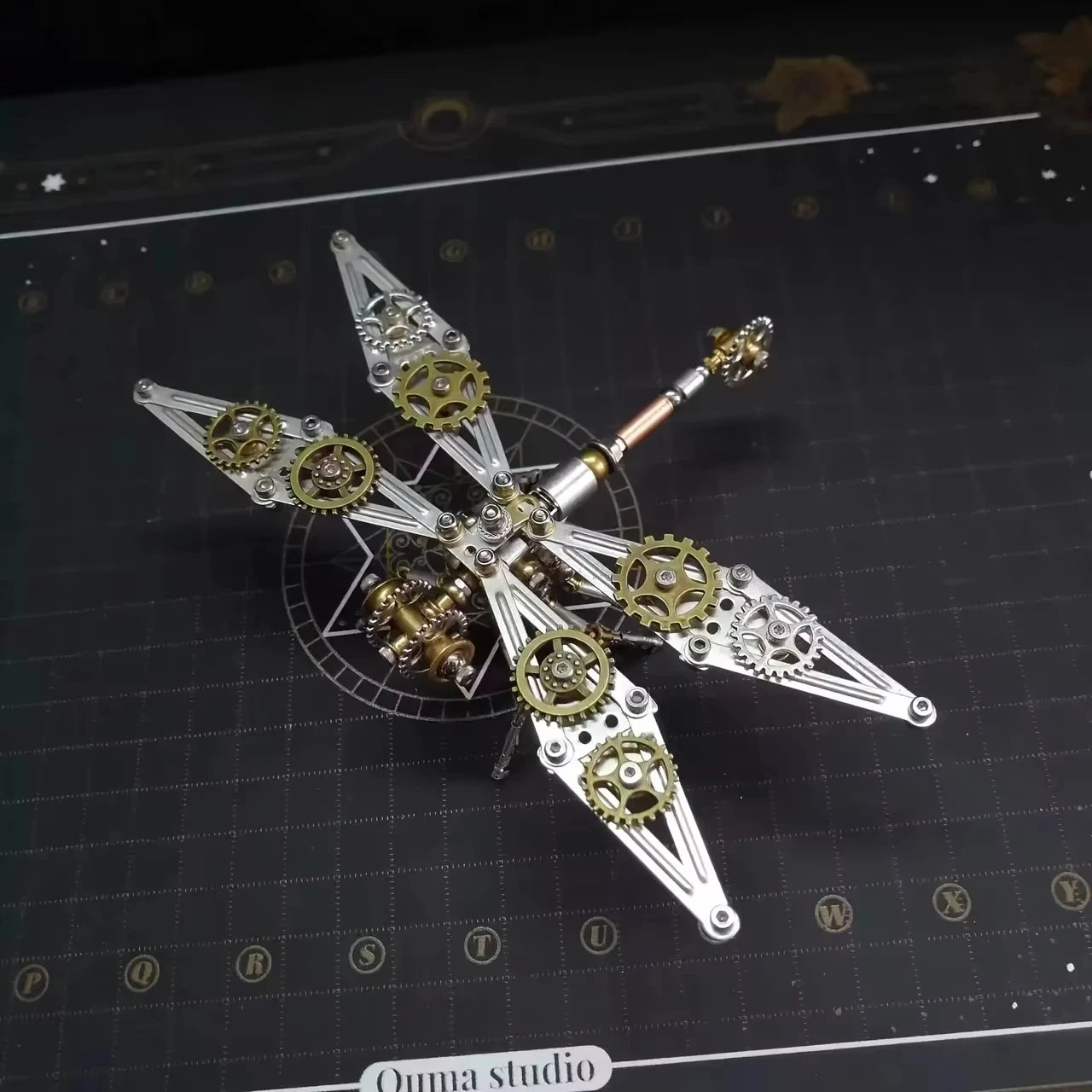 Steampunk dragonfly sculpture with gears on a dark grid background