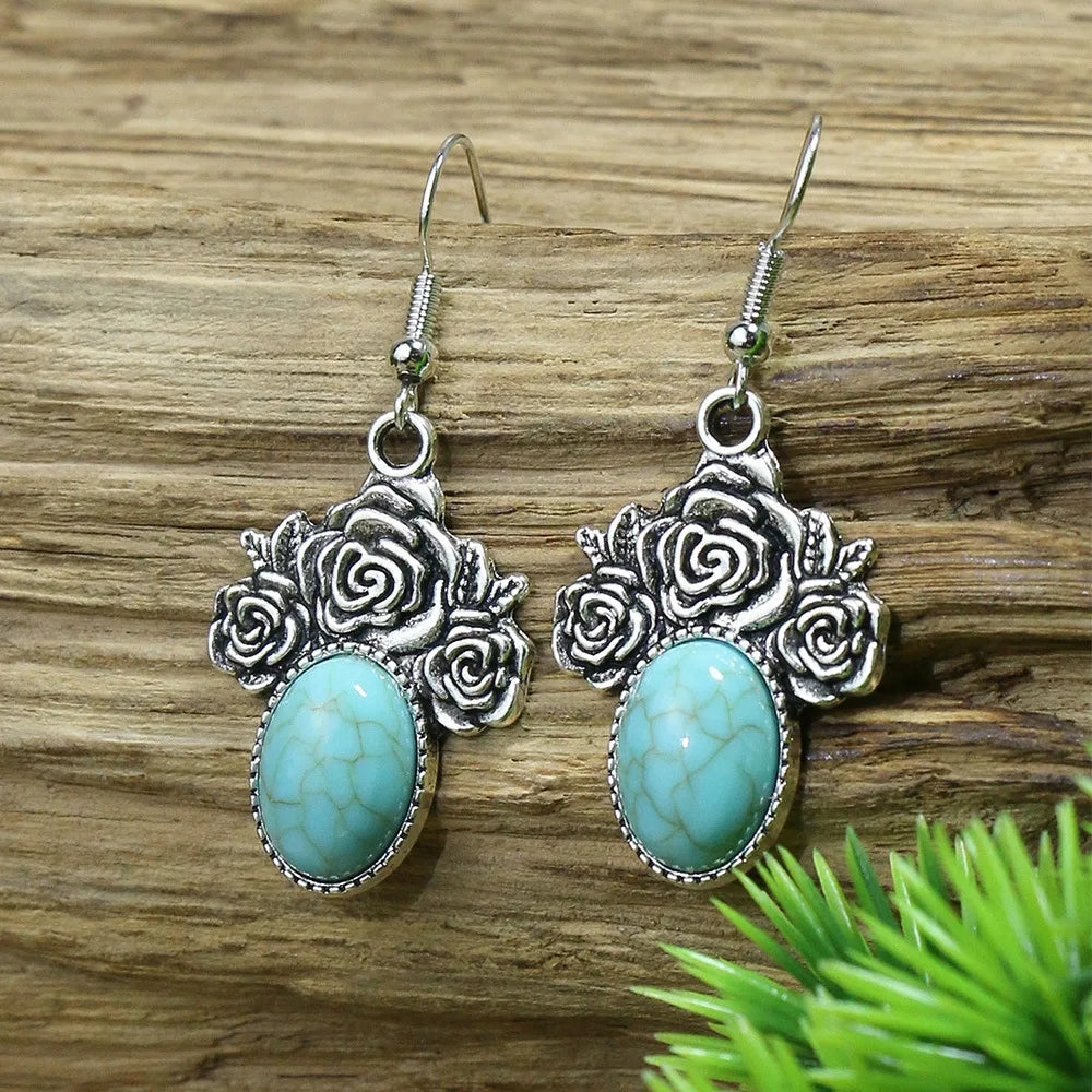 Silver earrings with turquoise stones on a wooden surface