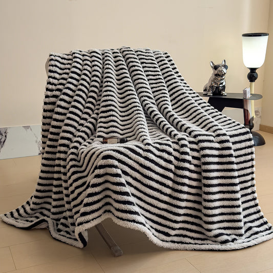 Black and white striped blanket draped over a chair in a room with a lamp and small table.