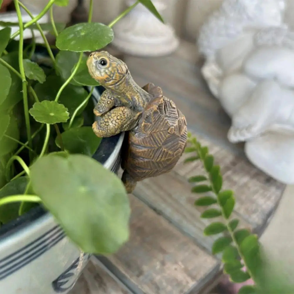 Decorative turtle figurine on a plant with a blurred background
