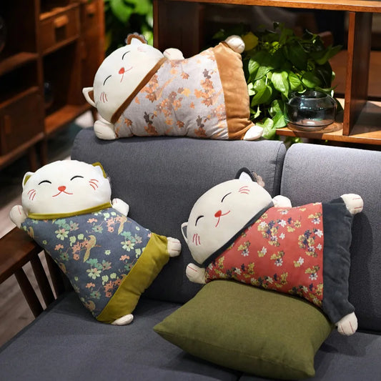 Japanese-inspired reclining cat cushion with a soft floral patterned body, shown in a selection of colourful designs for sofas and chairs.