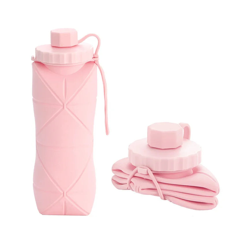 Collapsible pink water bottle with carrying strap on a white background