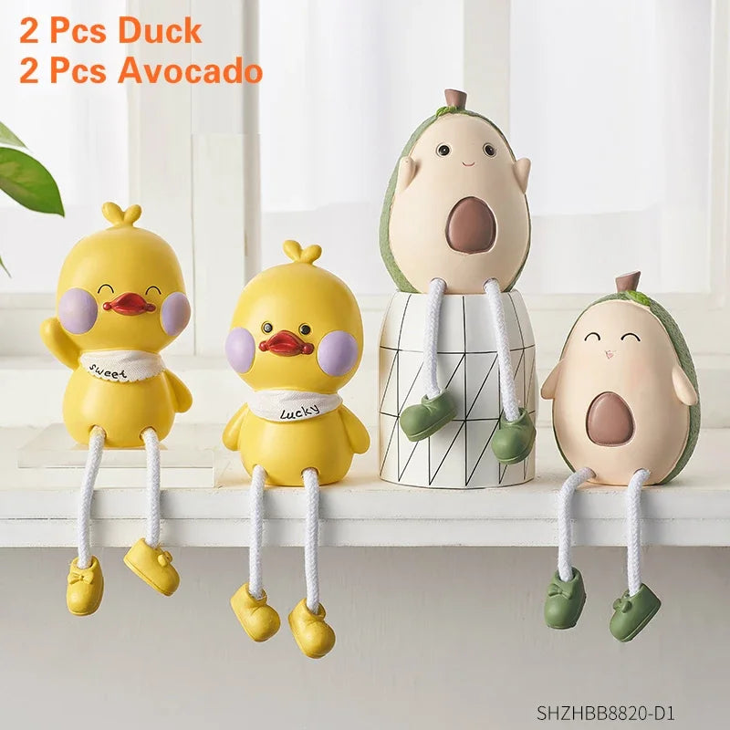 Two duck-shaped and two avocado-shaped toys on a white surface with a light background.
