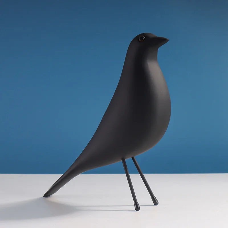 Black bird-shaped object on a white surface with a blue background