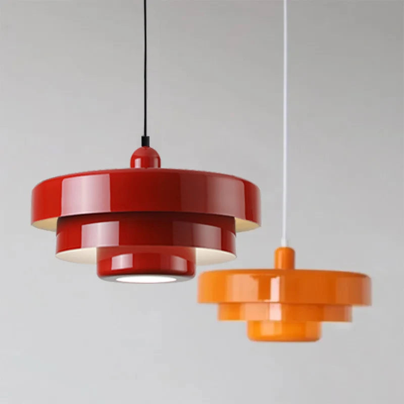 Two pendant lights, one red and one orange, on a gray background