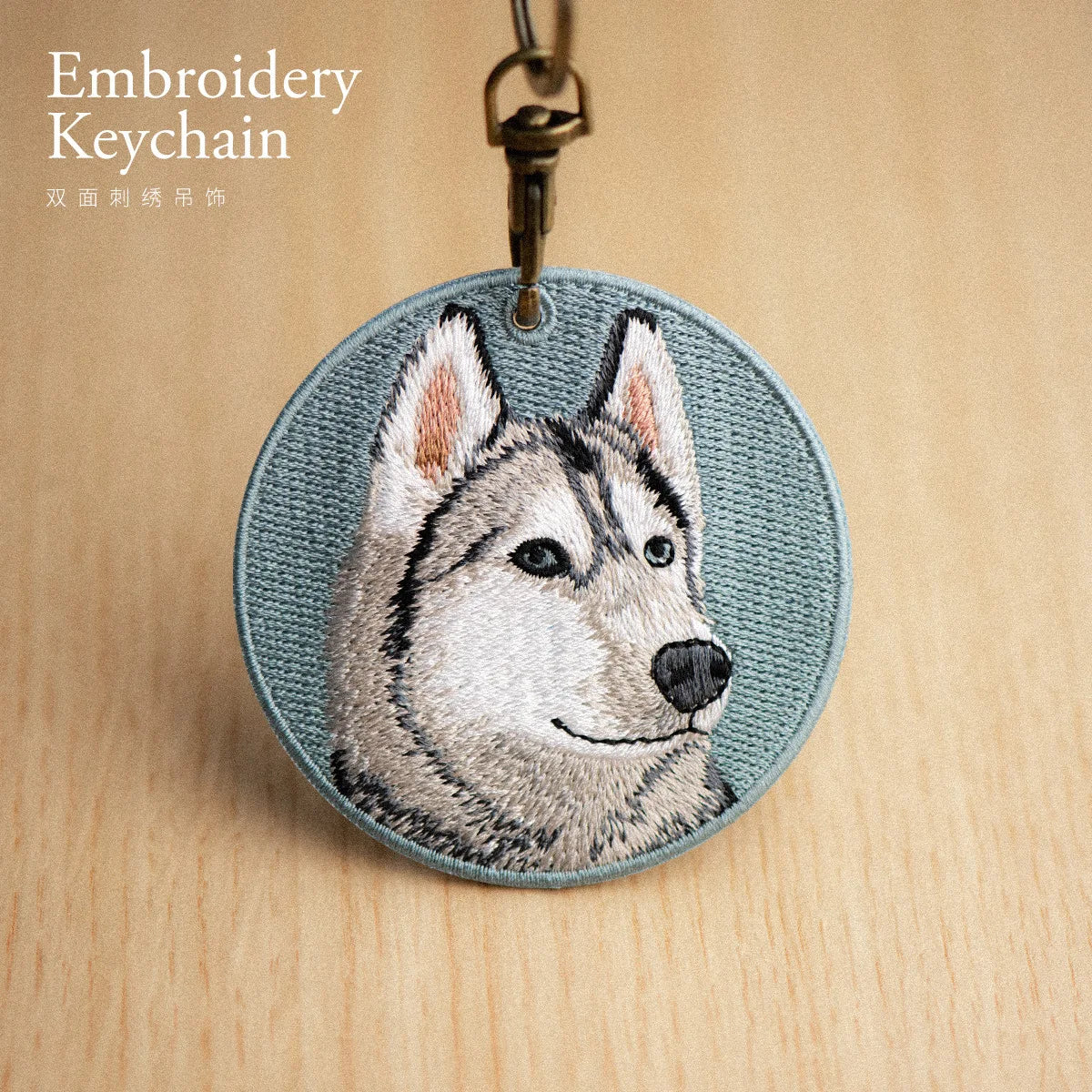 Embroidery keychain with a husky design on a wooden surface