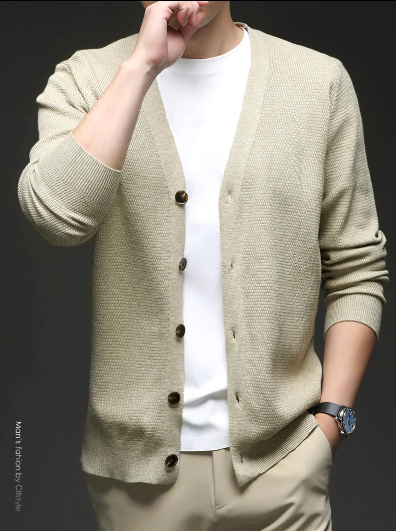 Beige cardigan worn by a person on a black background