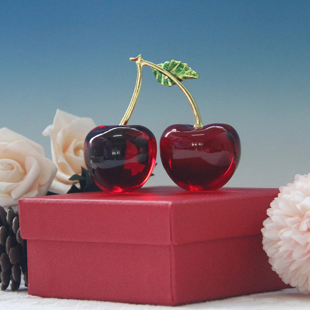 Decorative cherries with gold stems on a red box against a blue background
