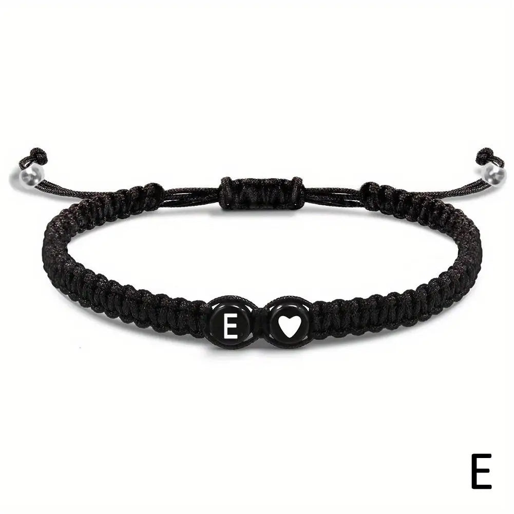 Black braided bracelet with letter 'E' charm on a white background