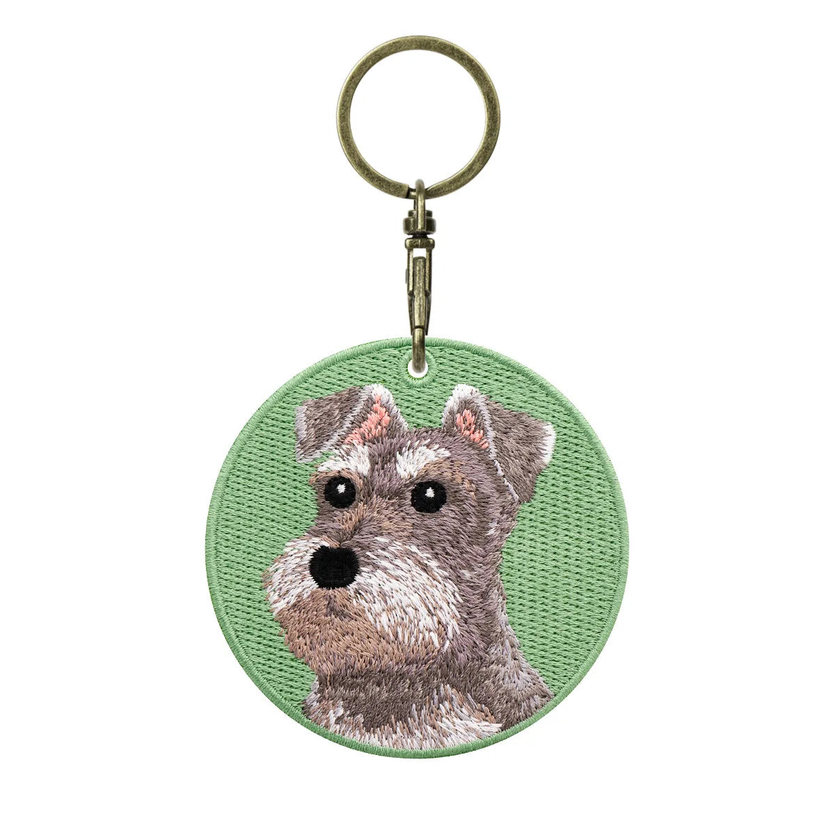 Keychain with embroidered dog design on a green background