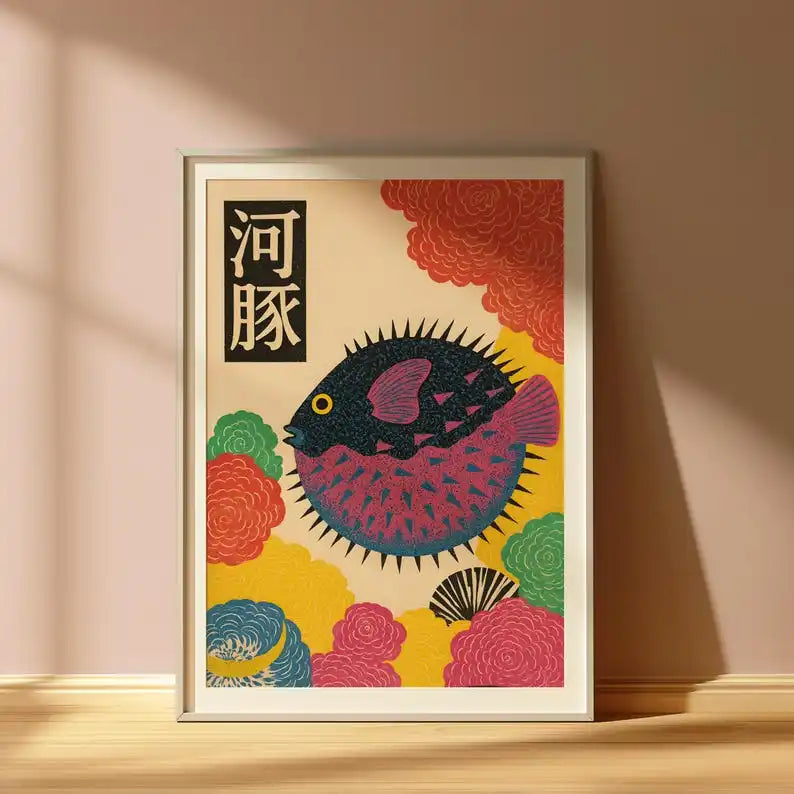 Colourful Japanese-inspired puffer fish canvas artwork featuring a dark blue and pink fish surrounded by stylised coral, yellow and teal flowers, displayed in a light wooden frame.
