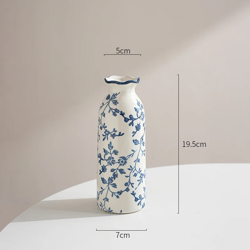 Ceramic vase with blue floral patterns and measurements on a neutral background