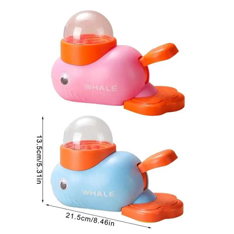 Two toy whales, one pink and one blue, with orange accents on a white background.