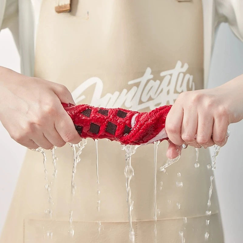 Person holding a red and black checkered towel with water splashing around, wearing a beige apron.