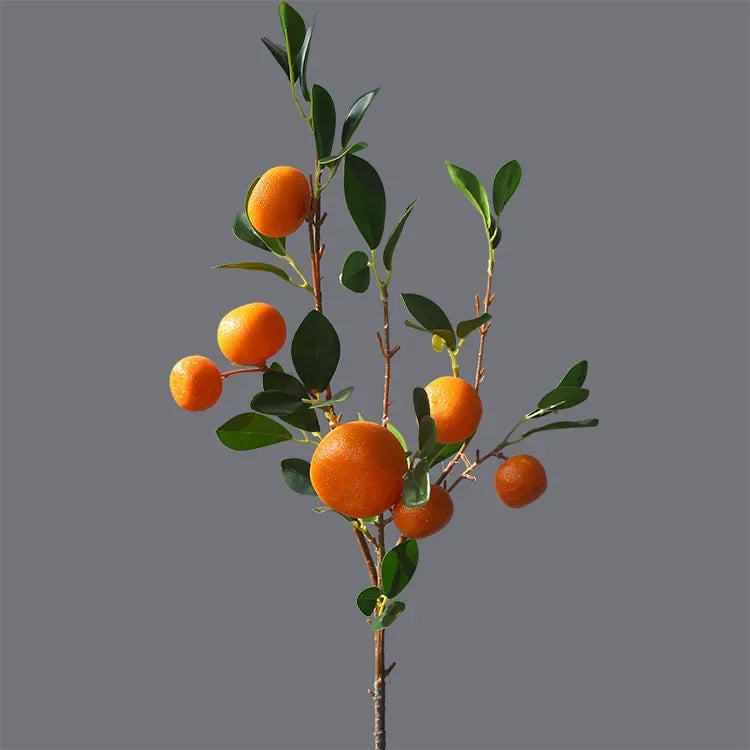 Artificial orange tree branch with oranges on a gray background