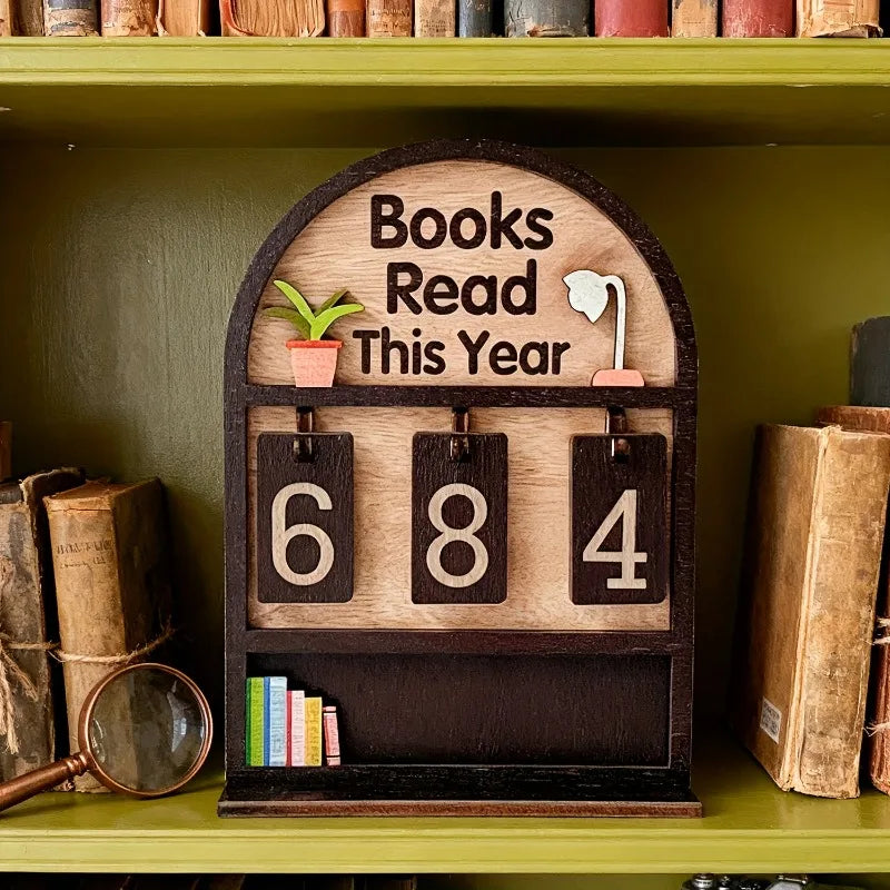 Wooden plaque with 'Books Read This Year' display on a bookshelf.