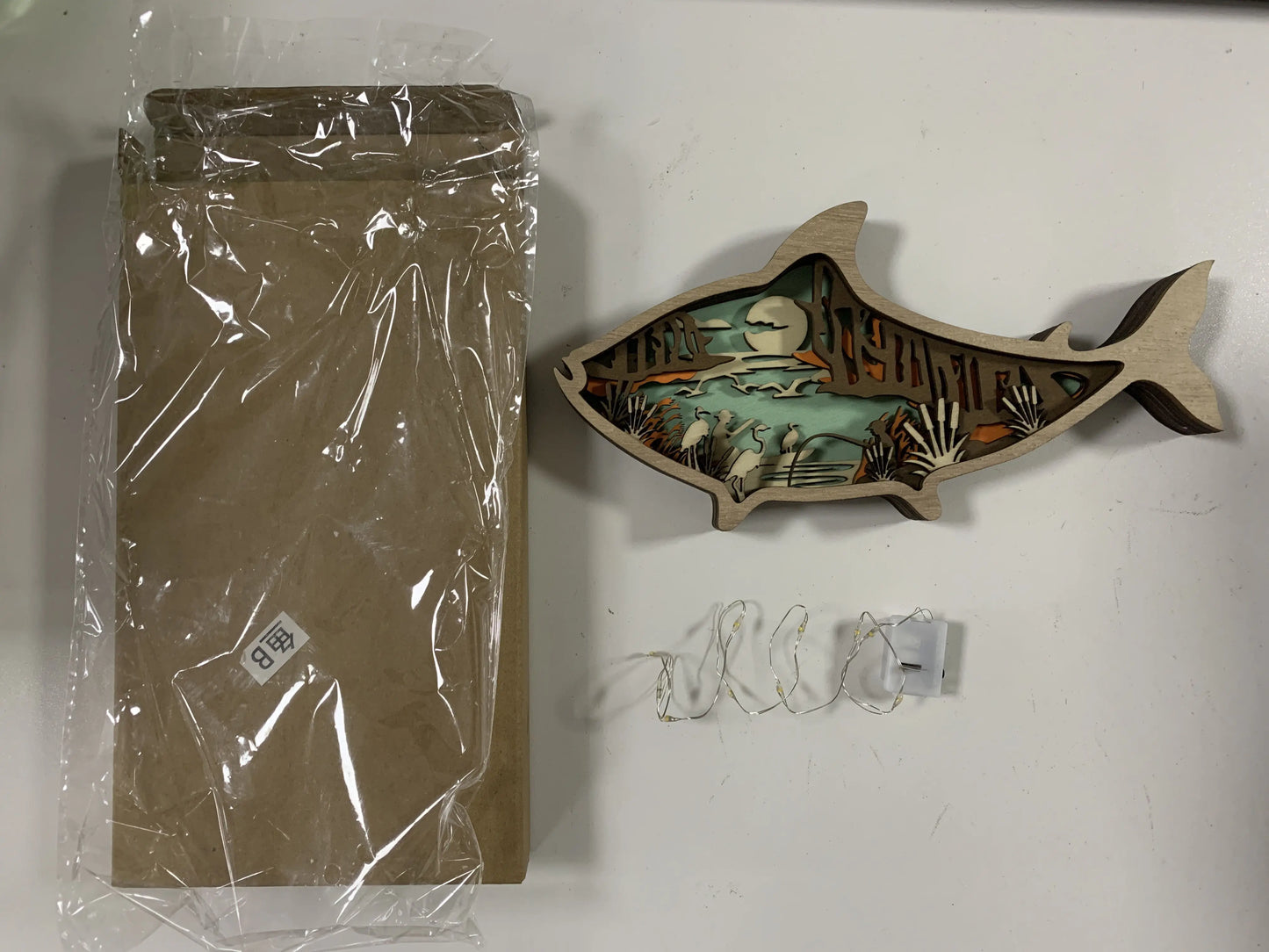 Decorative wall art fish with packaging on a white surface