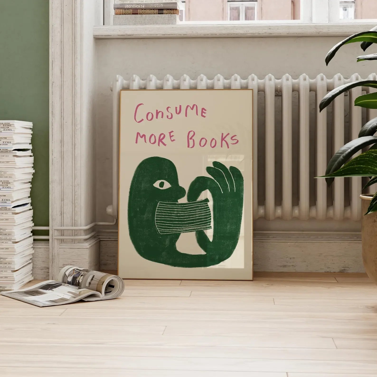 Poster with 'Consume More Books' text and green illustration of a hand holding a book in a room with books and a radiator.