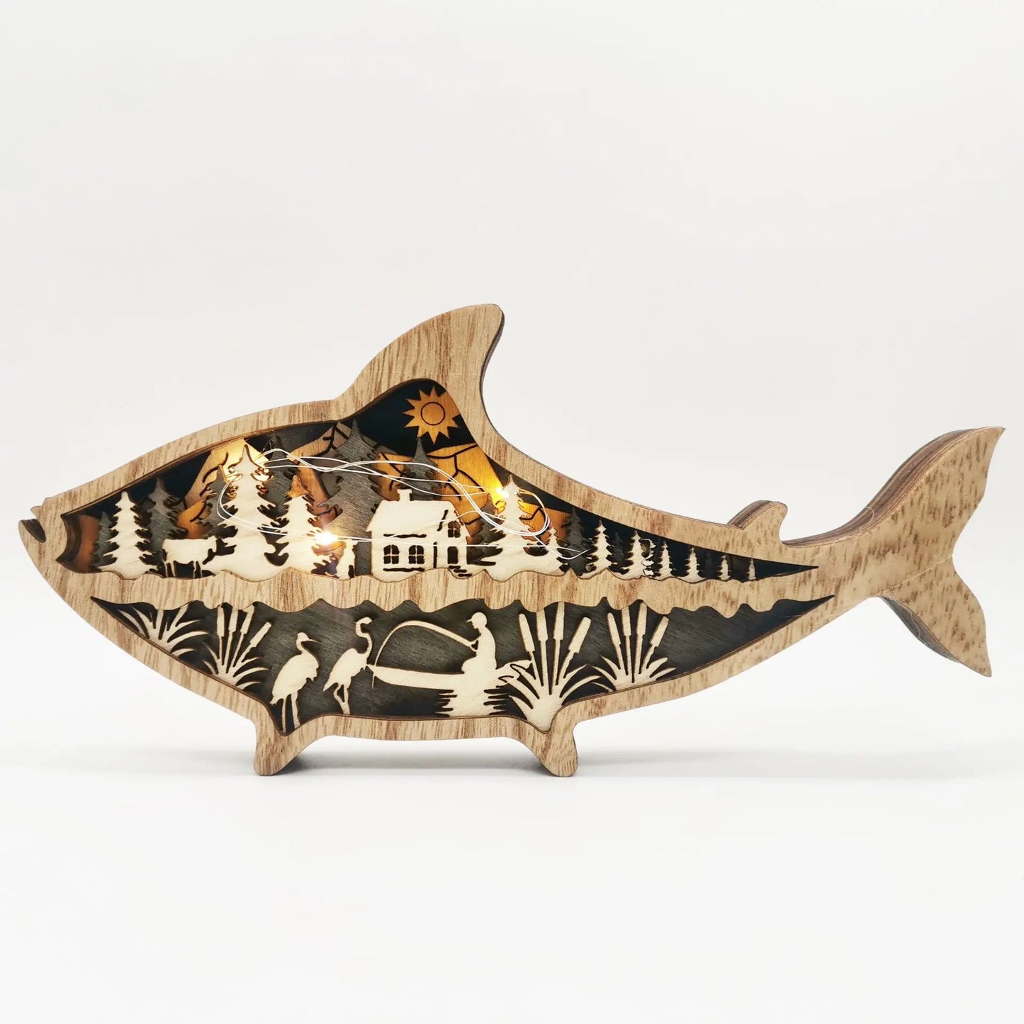Wooden fish-shaped decorative piece with cut-out scenes on a white background
