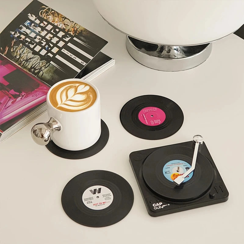 Set of six black vinyl record coasters with miniature turntable-style storage holder