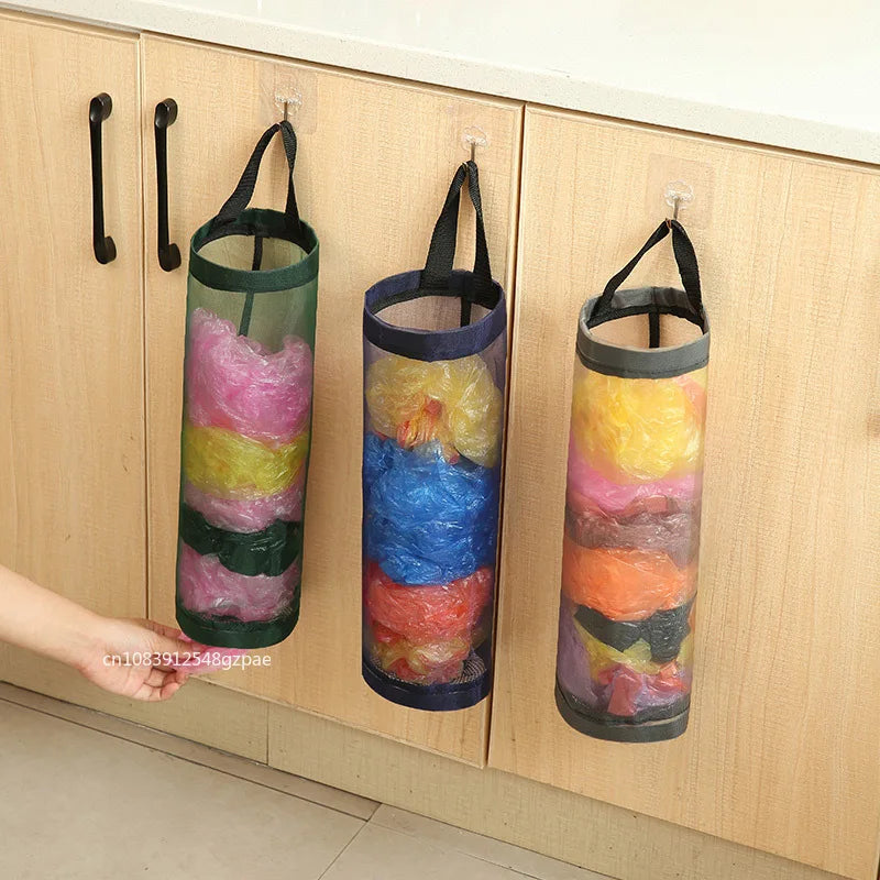 Three colorful plastic bag organizers hanging on a wooden cabinet.