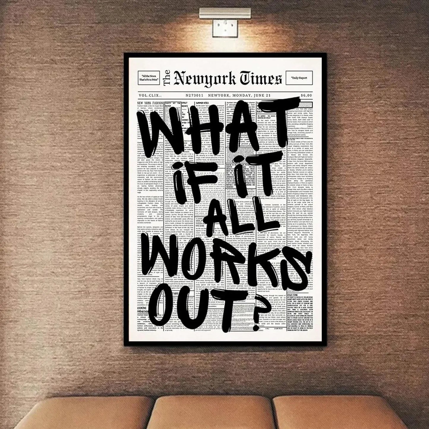 Framed New York Times newspaper with 'What if it all works out?' text on a wall above a sofa.