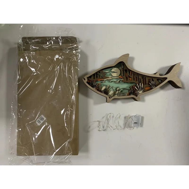 Decorative fish-shaped wall art with packaging on a white background