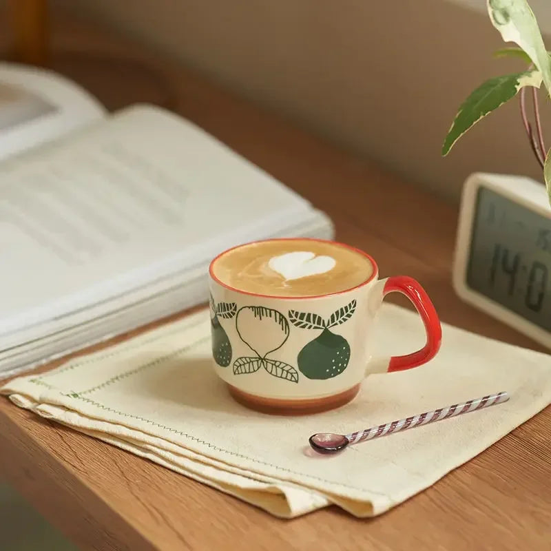 Ceramic mug with a heart design on a wooden surface with a plant and digital clock in the background.