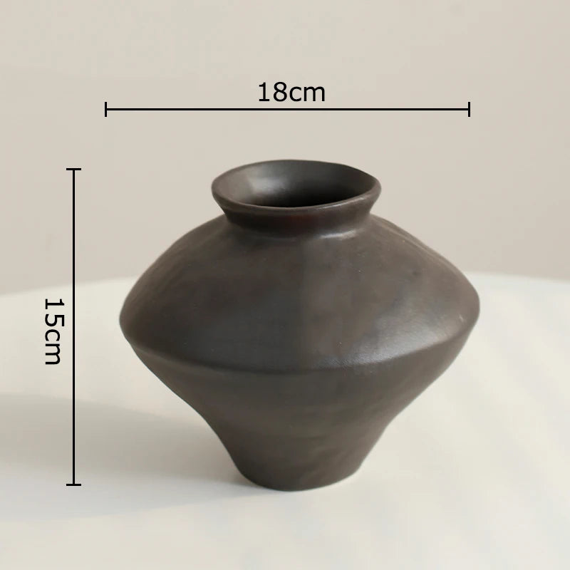 Black ceramic vase with measurements on a light background