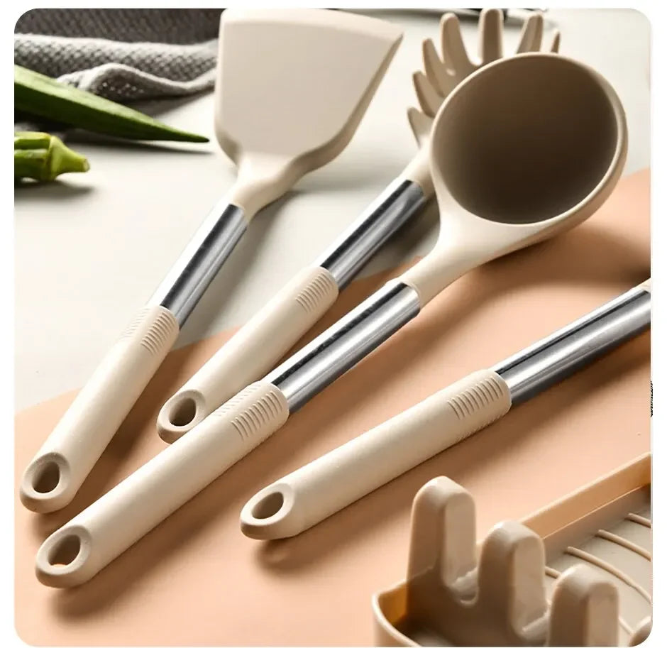 Set of beige kitchen utensils with metal handles on a light background