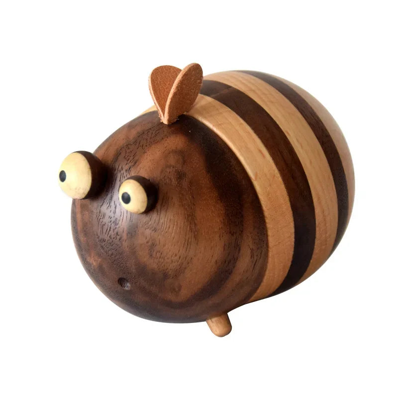Two handcrafted wooden bee toothpick holders with striped natural wood finish displayed on a wooden tabletop as decorative kitchen accessories.