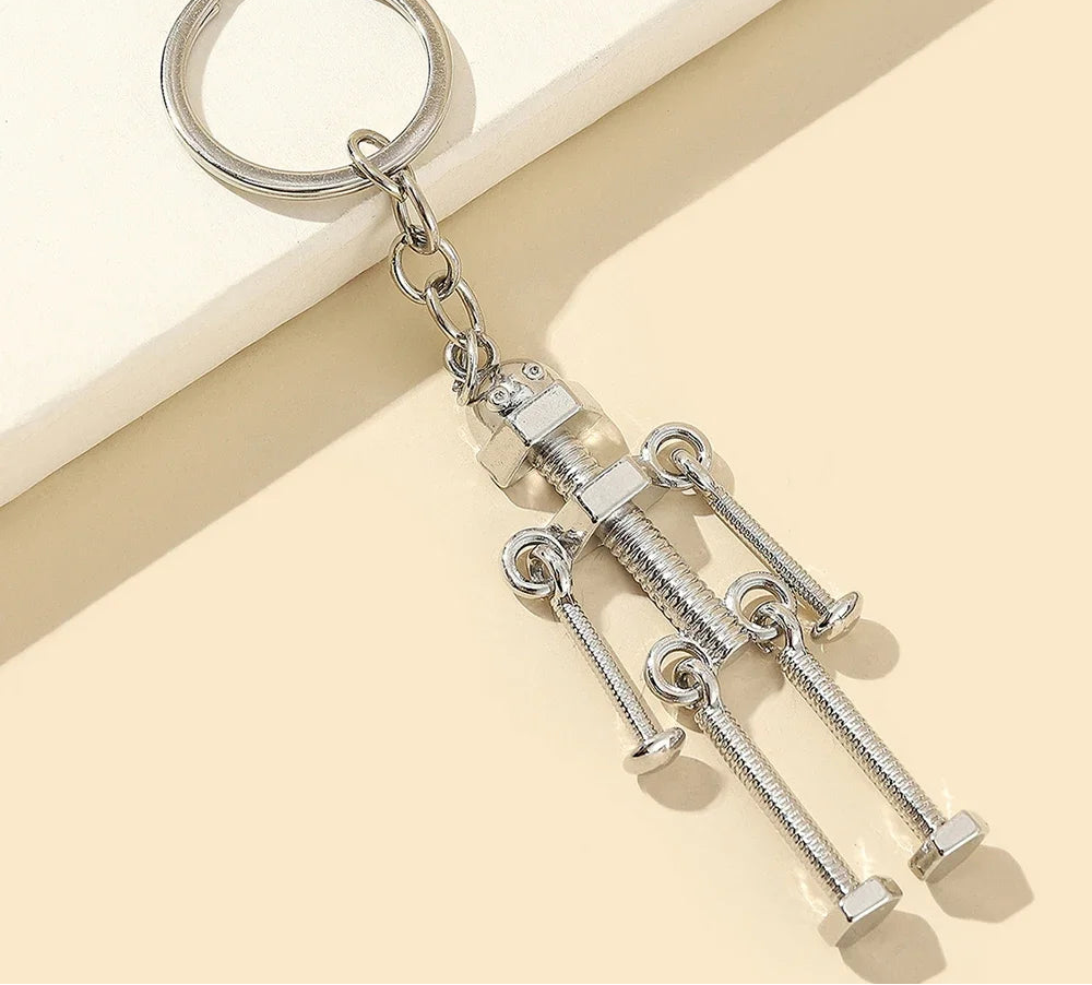 Silver keychain with mechanical design on a beige background