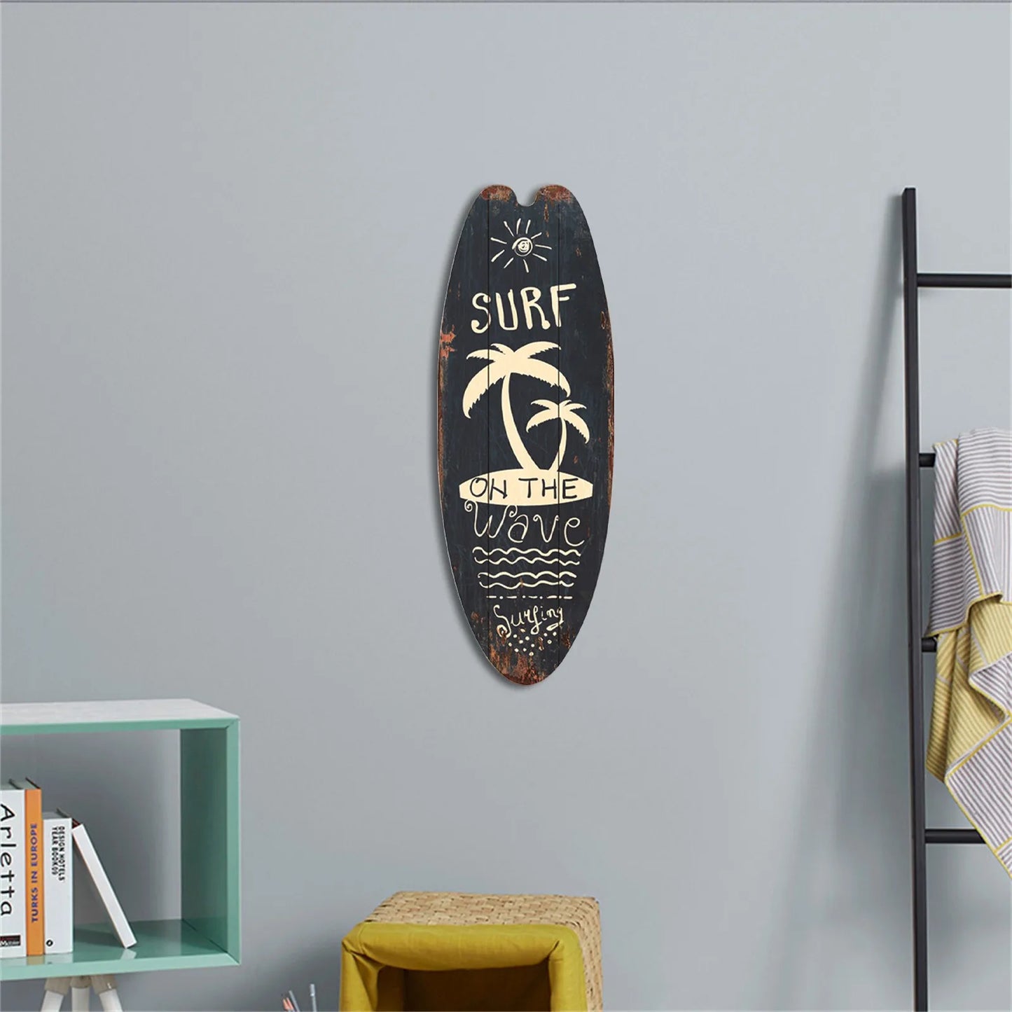 Decorative surfboard with 'Surf on the Wave' text and palm tree design on a gray wall.