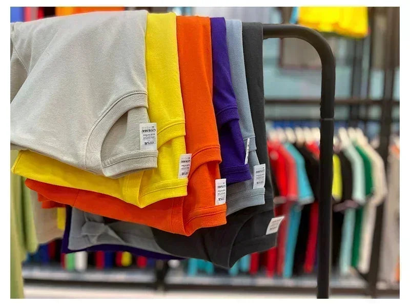 Colorful t-shirts on a rack with visible brand labels.