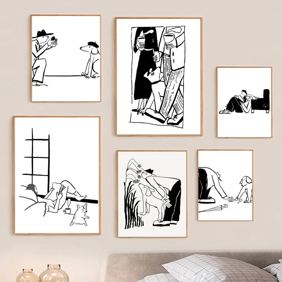 Six framed black and white minimalist cartoon art prints arranged on a beige wall above a bed, with a small lamp visible in the lower left corner.