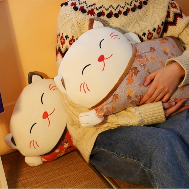 Person holding a plush cat pillow with another cat-shaped pillow on a wooden floor.