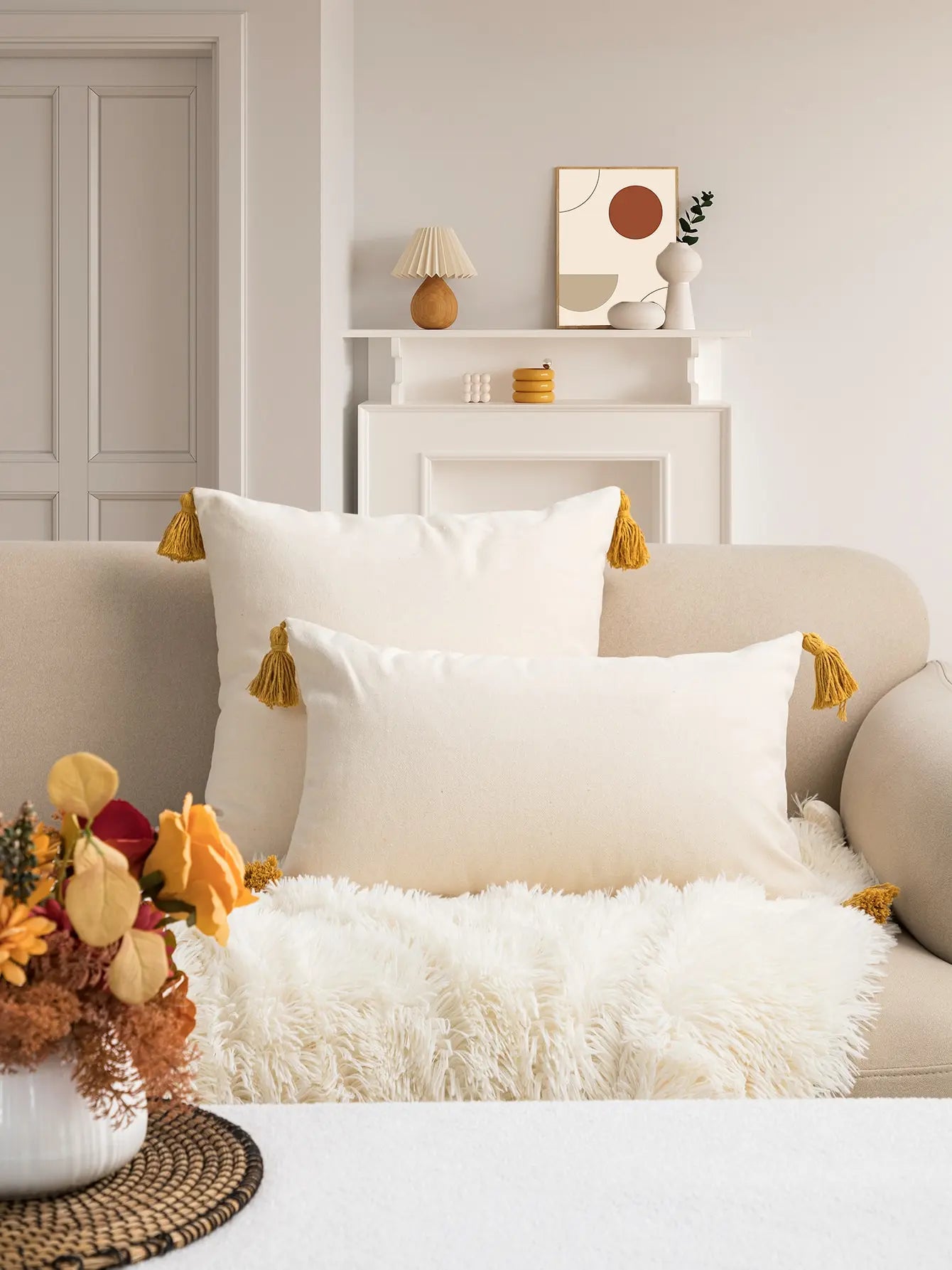 Decorative pillows with tassels on a sofa in a living room setting.