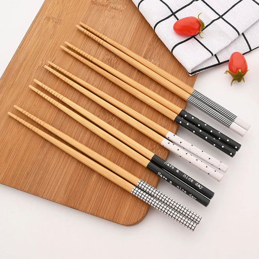 Five-pair bamboo chopsticks set with patterned anti-slip handles on a white background