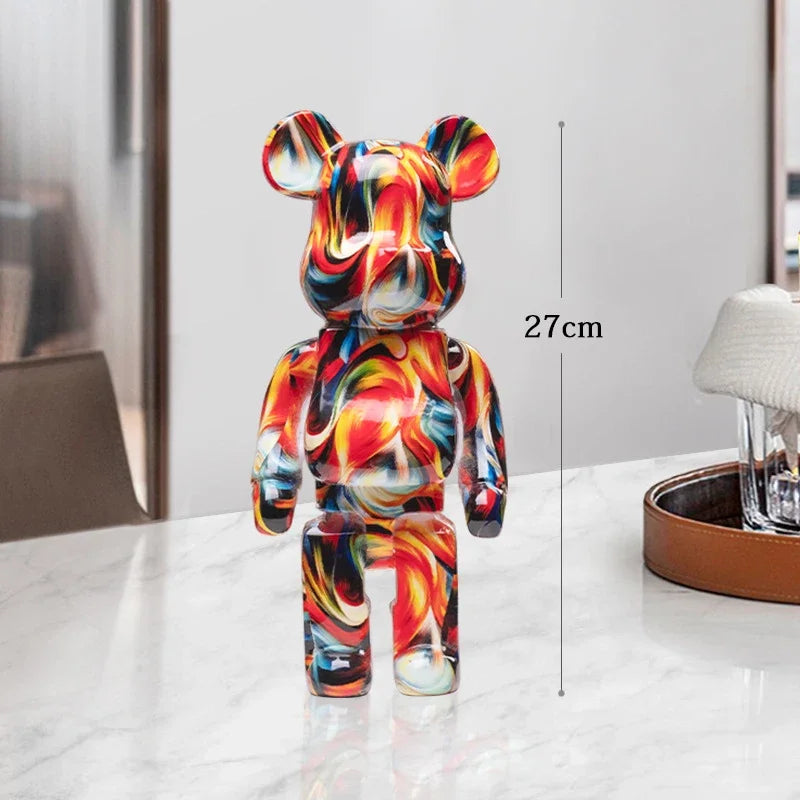 Colorful bear-shaped figurine on a white surface with a measurement label indicating 27cm.