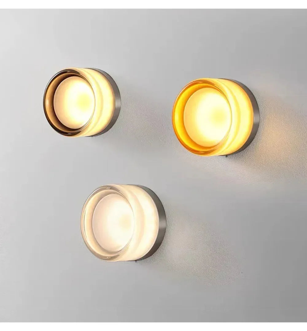 Round jelly-style glass LED wall lamp in amber on a modern wall.