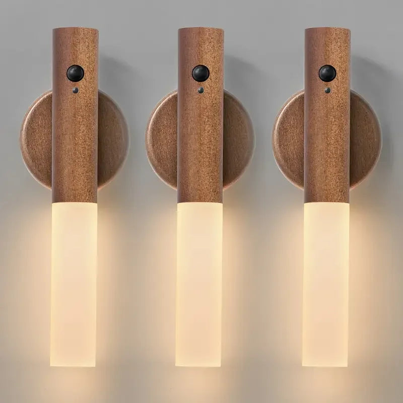 Three wooden wall sconces with light fixtures on a neutral background